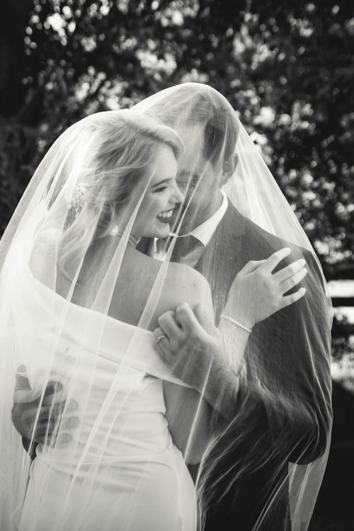 Wedding photography of bridal couple laughing in veil by Unix photography Wedding photography of bridal couple laughing in veil by Unix photography