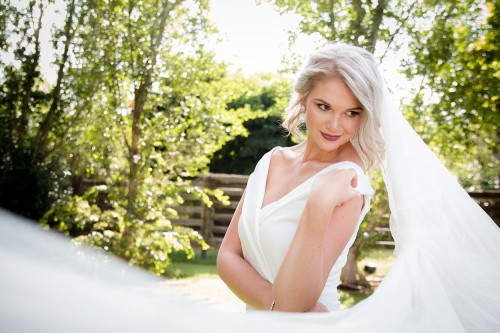 Wedding photography of bride with veil looking over shoulder by Unix photography Wedding photography of bride with veil looking over shoulder by Unix photography