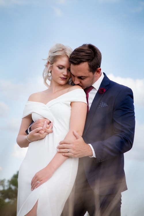 Bloemfontein photographer photo of groom kissing bride on shoulder Bloemfontein photographer wedding photography photo of groom kissing bride on shoulder