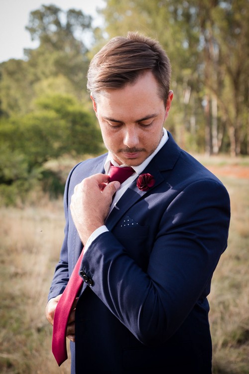 wedding photography of groom retouching tie and looking down photo by unix photography Bloemfontein photographer wedding photography groom retouching tie