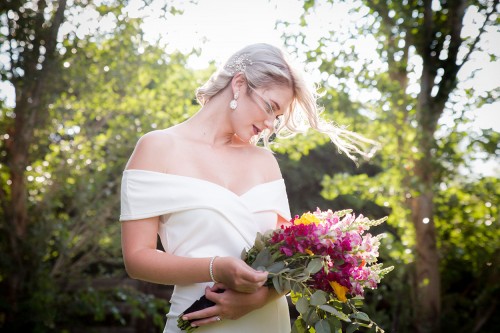 wedding photography of bride looking at her bouquet dreaming of wedding day Bloemfontein photographer wedding photography bride looking at her bouquet of flowers