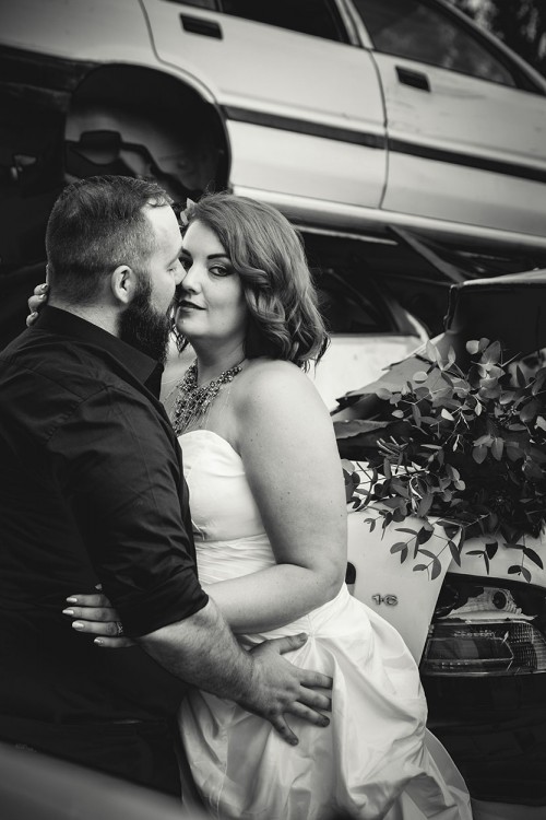 scrapyard theme bridal shoot bride sneaking a look at camera black and white photo by Unix photography Wedding photography in scrapyard bride sneaking a look at camera by Bloemfontein photographer Unix photography